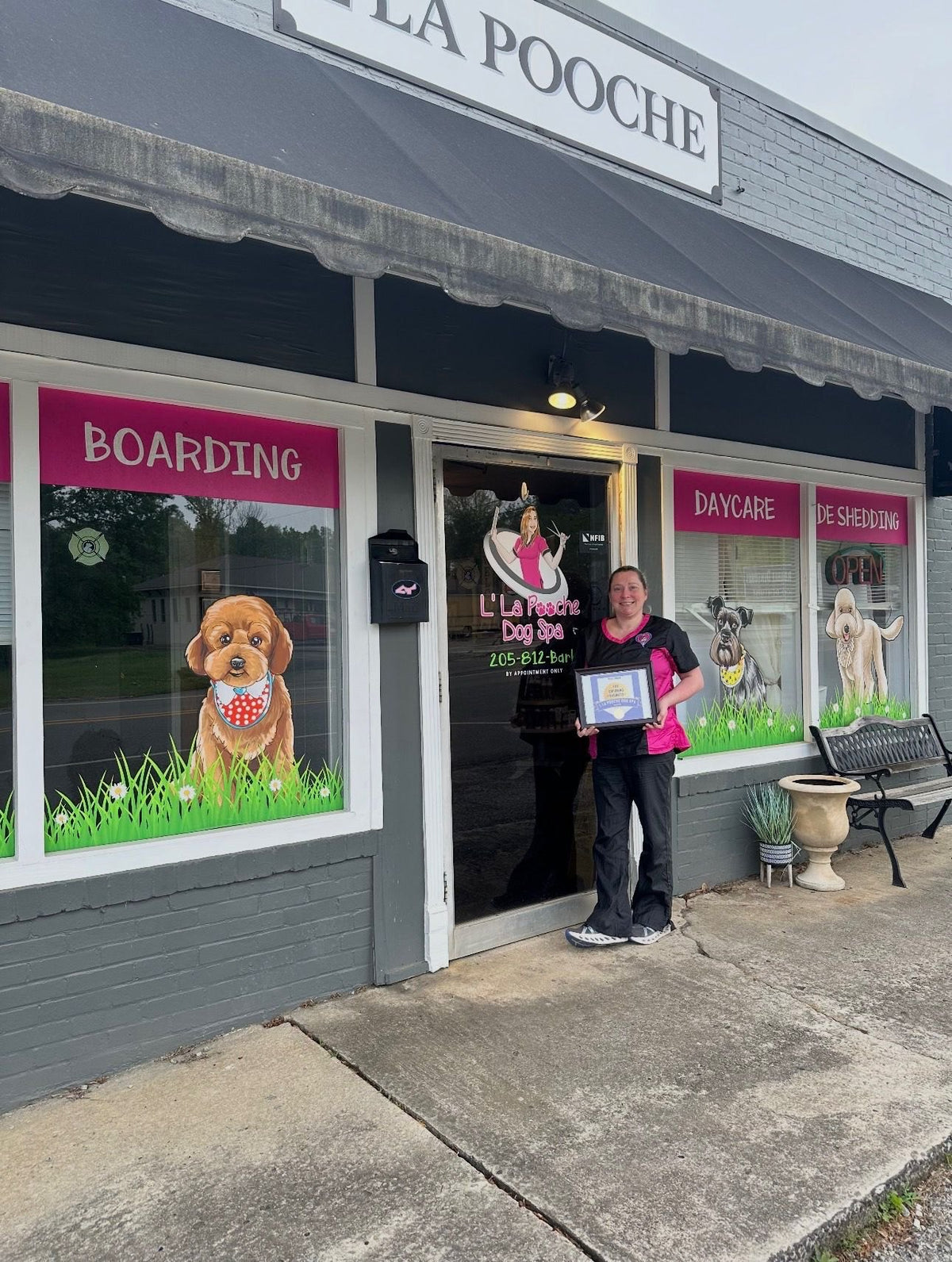 The L'La Pooche Dog Spa storefront with Kristy holding her Top Grooming Business award